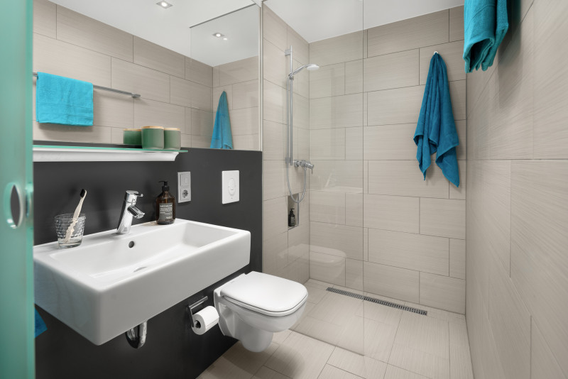 Modern bathroom with large mirror in the furnished apartment in Munich 