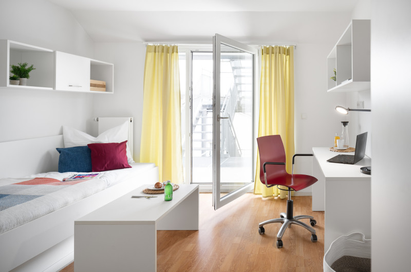 Möblierte Wohnung in München mit Einzelbett und Schreibtisch am Fenster 