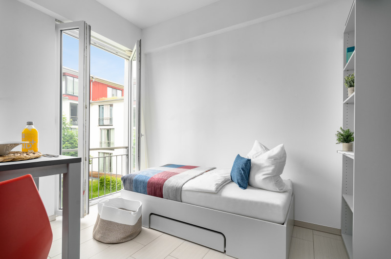 Gemütliches Bett mit Blick in den Innenhof in der möblierten Wohnung in Karlsruhe