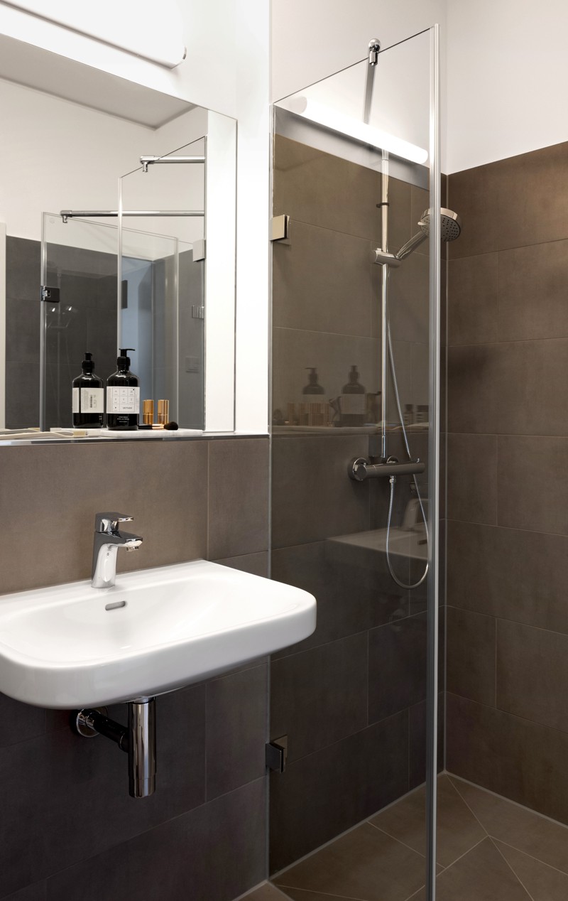 Badezimmer mit gläserner Duschkabine, Waschbecken und Spiegel