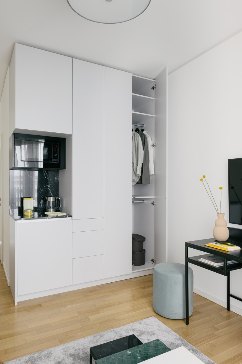 Interior view of the Micro Apartments in Berlin with view of white kitchenette