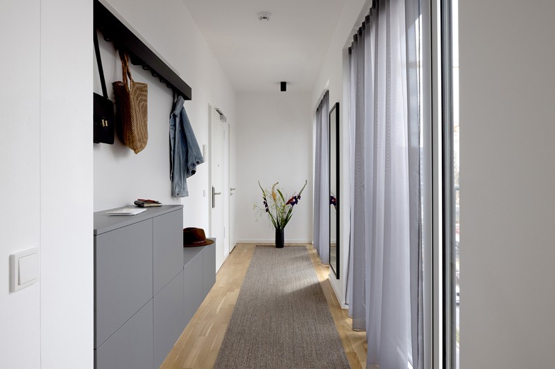 Bright hallway with gray carpet, gray furniture and gray curtains