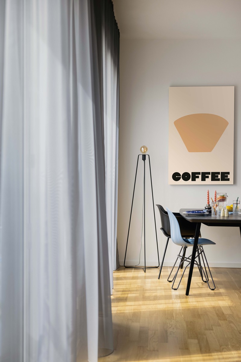 Coliving Space with parquet, gray curtains and a picture with Coffee