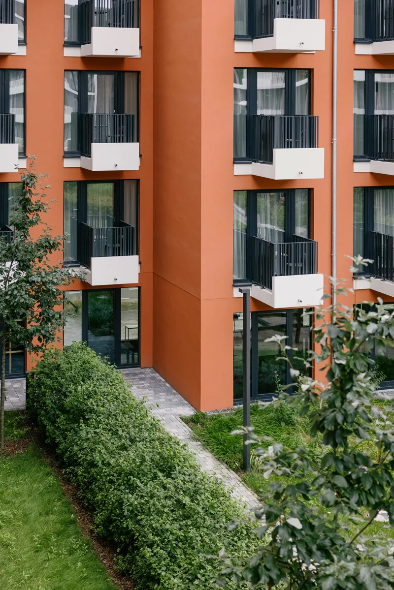 Balkone an der roten Hausfassade des Gebäudekomplexes zum Co-Living in Berlin 