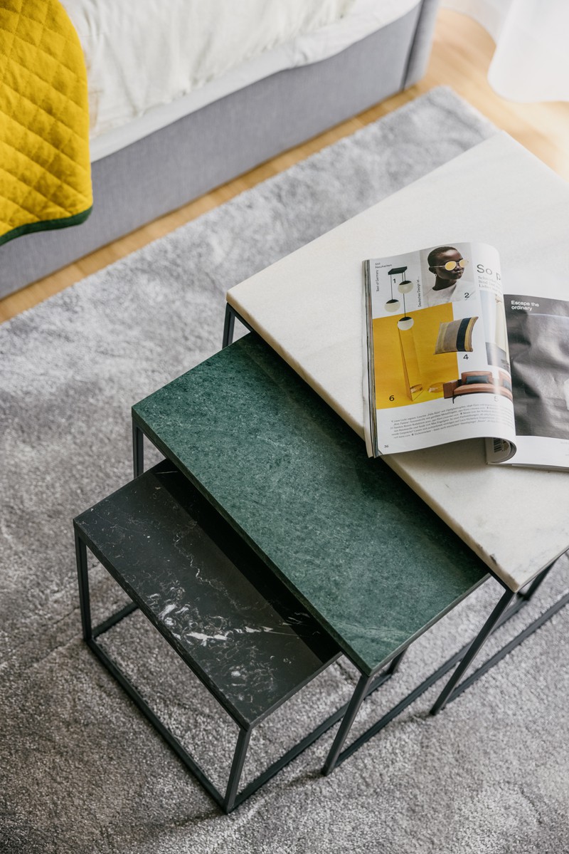 Extendable coffee table with magazine on a gray carpet