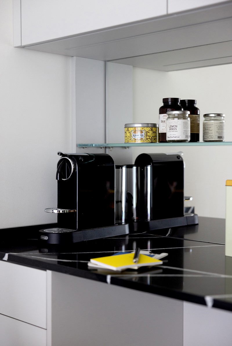 Kitchenette with black marble countertop and high quality espresso machine.