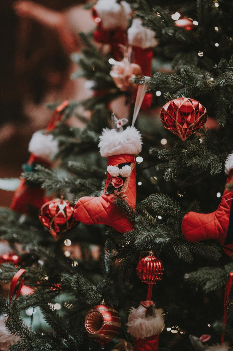 Rote Christbaumkugeln und andere Deko an einem Weihnachtsbaum