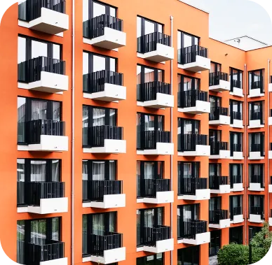 Bright orange apartment building with several floors, each featuring small white balconies with black railings. The modern facade gives a vibrant and uniform architectural impression.